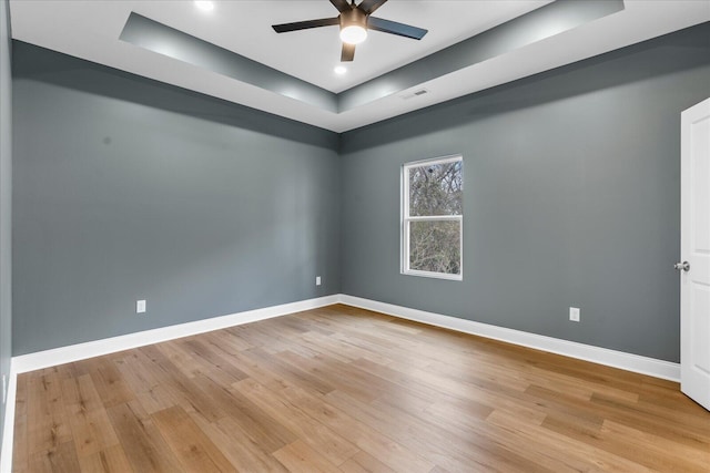 spare room featuring visible vents, ceiling fan, light wood-style flooring, and baseboards