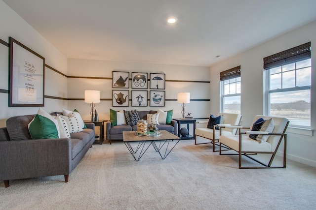 living area featuring baseboards and light colored carpet