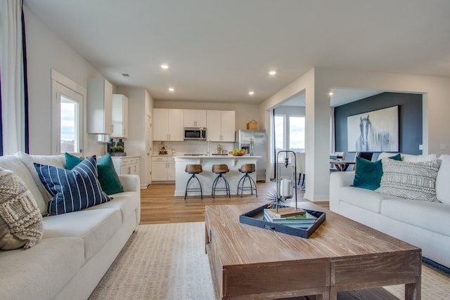 living area featuring light wood-type flooring, visible vents, and recessed lighting