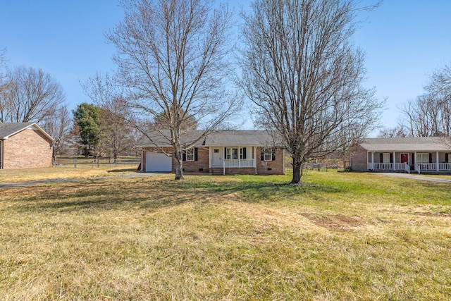 view of yard with a porch, an attached garage, and fence