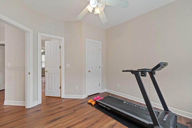 workout area featuring wood finished floors, a ceiling fan, and baseboards