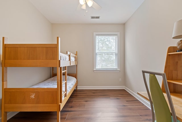 bedroom with a ceiling fan, wood finished floors, visible vents, and baseboards