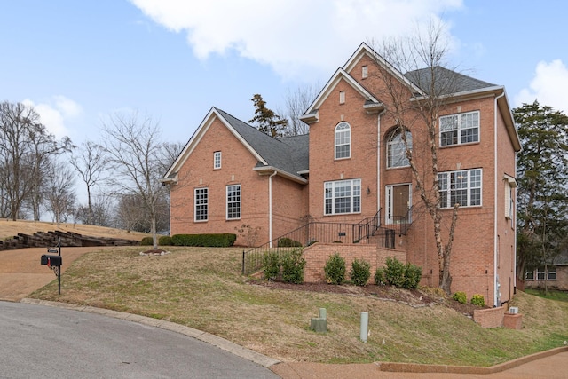 view of front of home with brick siding and a front lawn