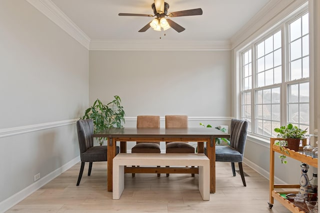 dining area featuring ornamental molding, light wood-type flooring, and baseboards