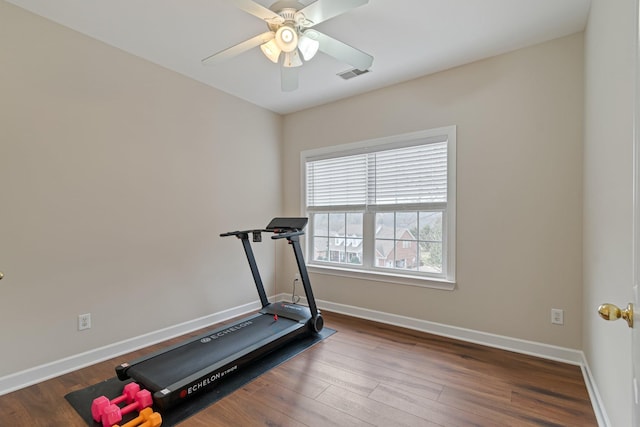 workout room with a ceiling fan, visible vents, baseboards, and wood finished floors