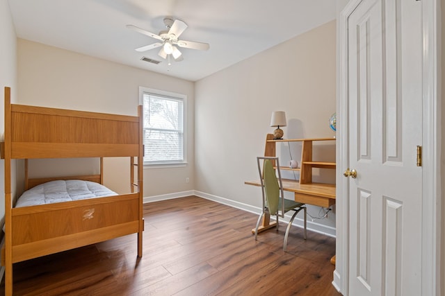 bedroom with wood finished floors, visible vents, and baseboards