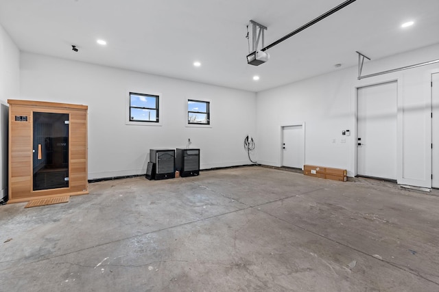 garage featuring a garage door opener, recessed lighting, and baseboards