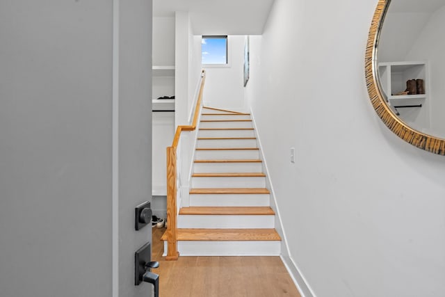 stairway with baseboards and wood finished floors