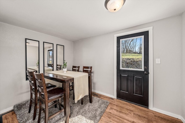 dining space with light wood finished floors and baseboards