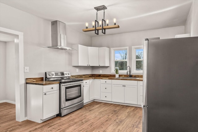 kitchen with appliances with stainless steel finishes, ventilation hood, a sink, and light wood-style floors