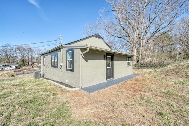 view of home's exterior featuring a yard, central AC unit, and stucco siding