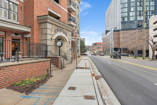 view of road featuring sidewalks, street lights, and curbs