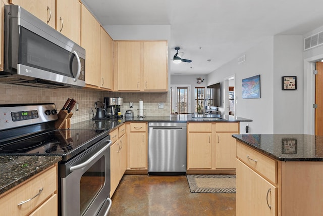 kitchen featuring tasteful backsplash, light brown cabinets, stainless steel appliances, and a sink