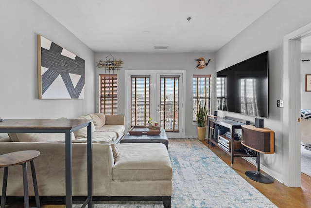 living room featuring baseboards, visible vents, and french doors