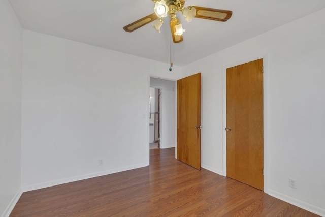 unfurnished bedroom with a ceiling fan, baseboards, and wood finished floors