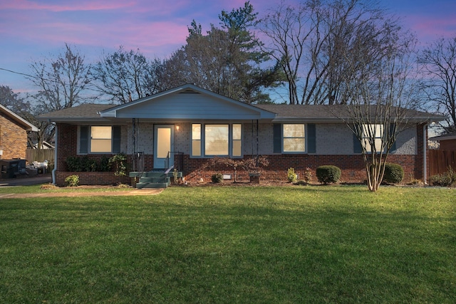 single story home featuring a front yard and brick siding