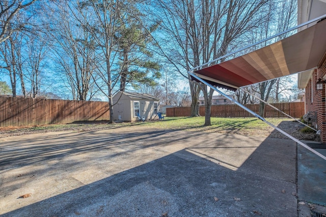 view of yard featuring a fenced backyard, a storage unit, and an outdoor structure