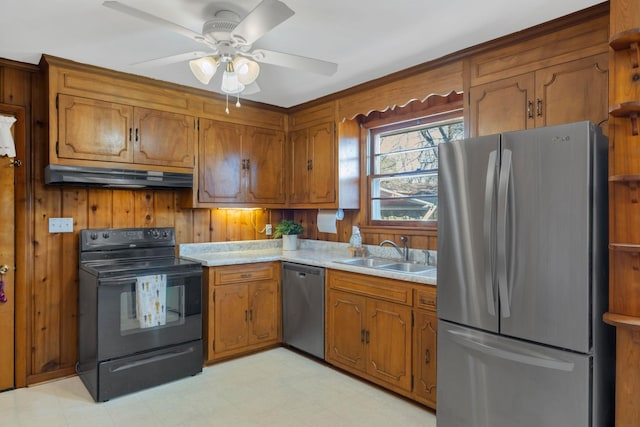 kitchen with under cabinet range hood, a sink, appliances with stainless steel finishes, brown cabinets, and light floors