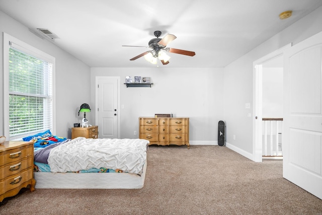 carpeted bedroom with visible vents, ceiling fan, and baseboards