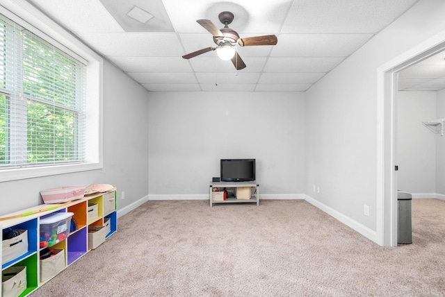 playroom featuring baseboards, carpet flooring, ceiling fan, and a drop ceiling