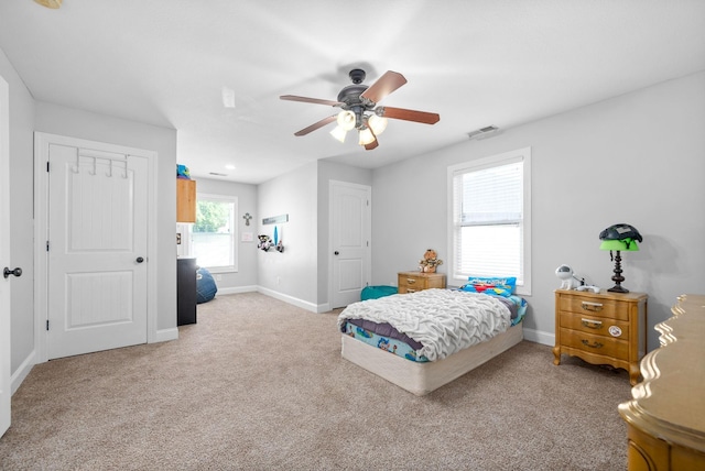 carpeted bedroom with visible vents, ceiling fan, and baseboards