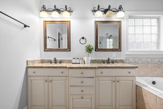 full bath with double vanity, a garden tub, a sink, and an enclosed shower