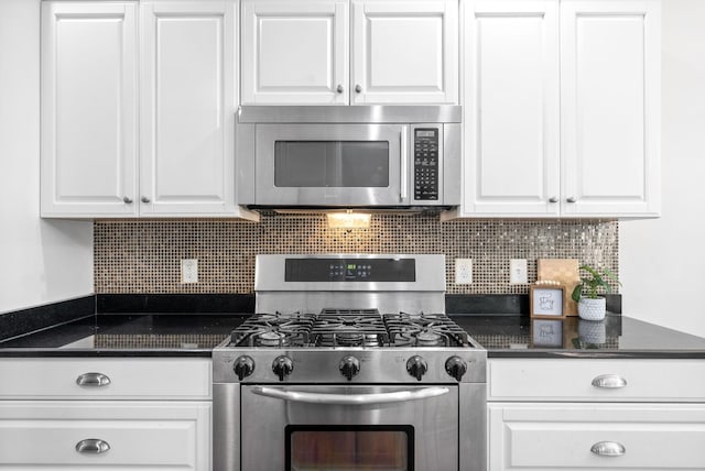 kitchen featuring dark countertops, tasteful backsplash, appliances with stainless steel finishes, and white cabinets