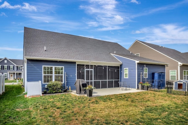 back of property featuring a patio, a shingled roof, fence, a sunroom, and a lawn