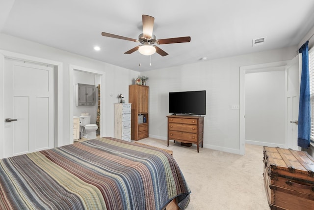 bedroom featuring light colored carpet, visible vents, ensuite bathroom, a ceiling fan, and baseboards