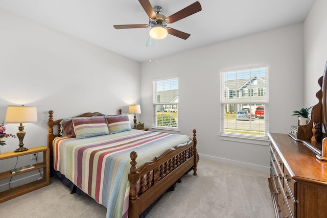 bedroom with light carpet, ceiling fan, and baseboards