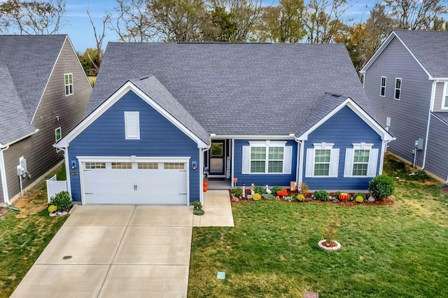 view of front of house featuring a garage, driveway, a front lawn, and a shingled roof