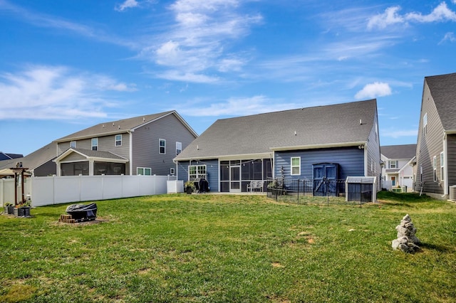 back of house with a sunroom, fence, and a yard