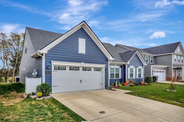 view of front of house featuring a garage, a front lawn, concrete driveway, and roof with shingles