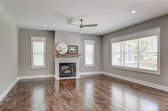 unfurnished living room with dark wood-style flooring, visible vents, a fireplace, and baseboards