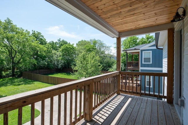 wooden terrace with a lawn and fence