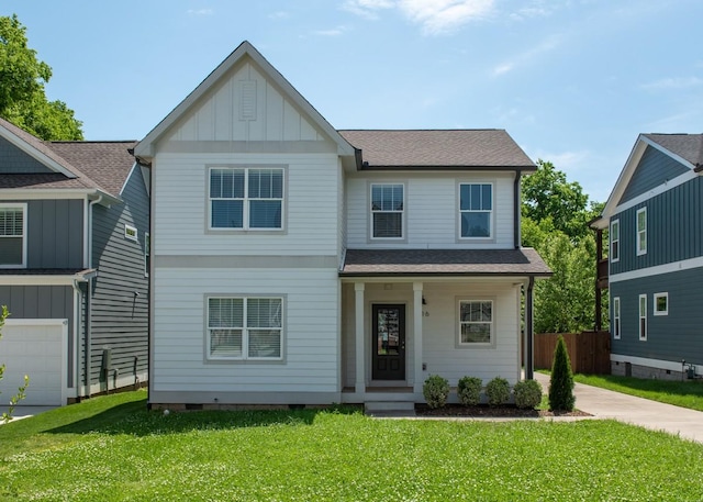 view of front of home with a shingled roof, fence, a front lawn, and board and batten siding