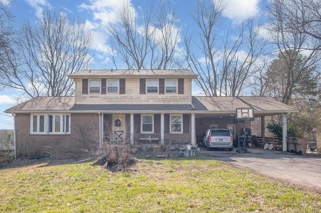 view of front of house featuring driveway, an attached carport, and a front yard