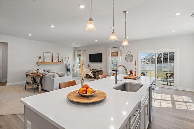 kitchen featuring light wood-style floors, a sink, and recessed lighting