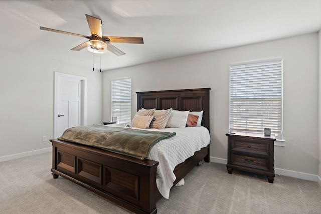 bedroom featuring light carpet, ceiling fan, and baseboards