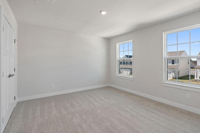 spare room featuring carpet floors and baseboards