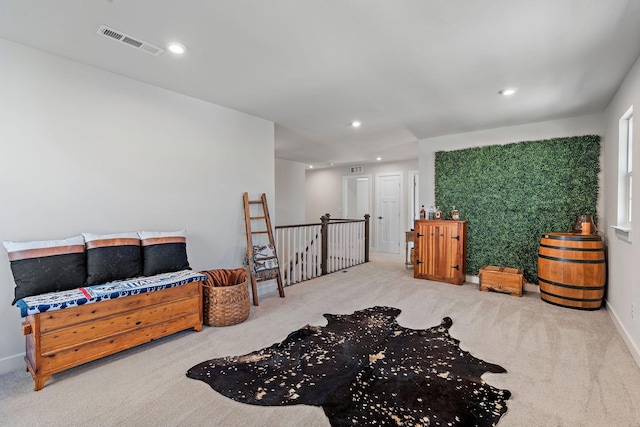 sitting room with recessed lighting, carpet, visible vents, and an upstairs landing