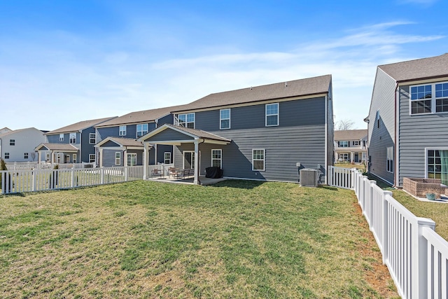 rear view of house featuring a yard, a patio, central AC, a residential view, and a fenced backyard