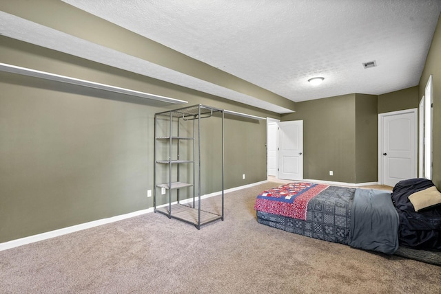 carpeted bedroom with a textured ceiling, visible vents, and baseboards