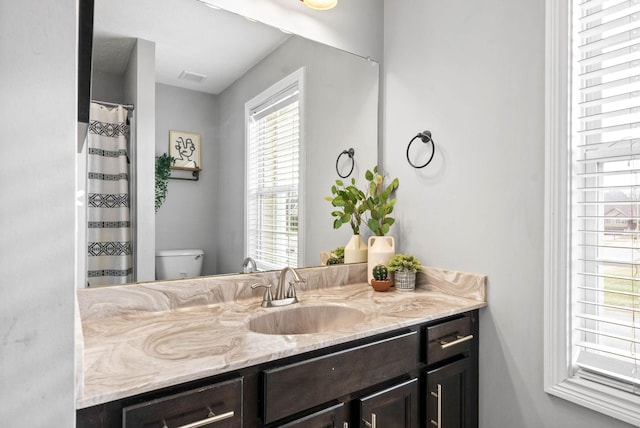 full bathroom with visible vents, vanity, and toilet