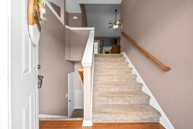 stairs with ceiling fan, baseboards, and wood finished floors