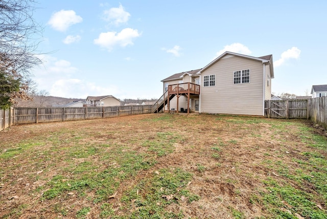 view of yard with stairs, a deck, and a fenced backyard