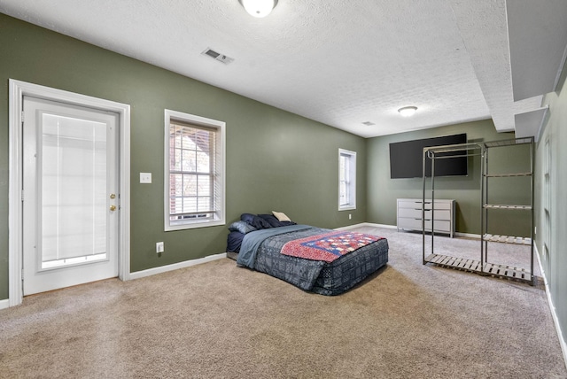 bedroom with baseboards, carpet, visible vents, and a textured ceiling