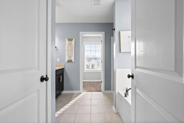 full bath featuring tile patterned flooring, a garden tub, vanity, visible vents, and baseboards