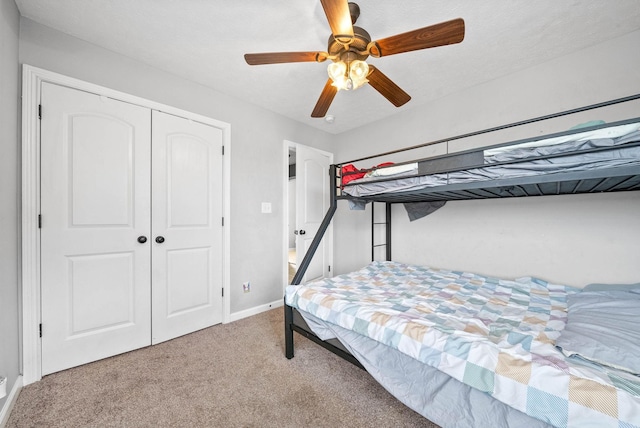 carpeted bedroom featuring a closet, a ceiling fan, and baseboards