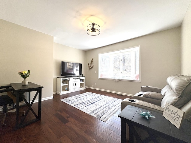 living room featuring visible vents, baseboards, and wood finished floors